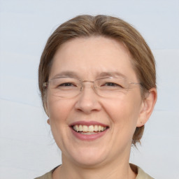 Joyful white adult female with medium  brown hair and blue eyes