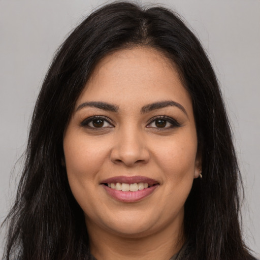 Joyful latino young-adult female with long  brown hair and brown eyes