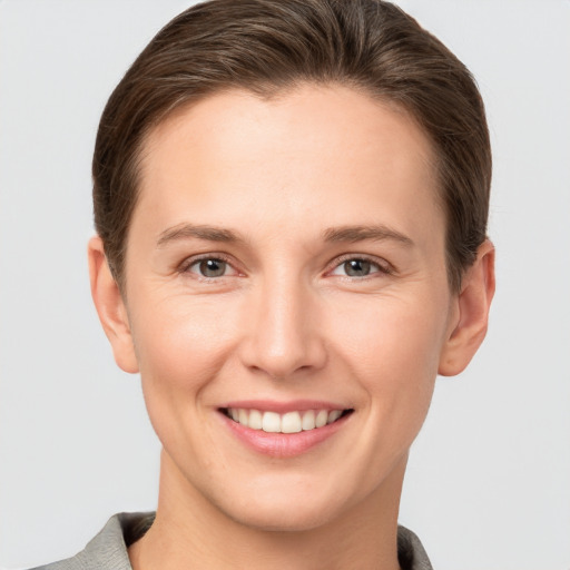 Joyful white young-adult female with short  brown hair and grey eyes