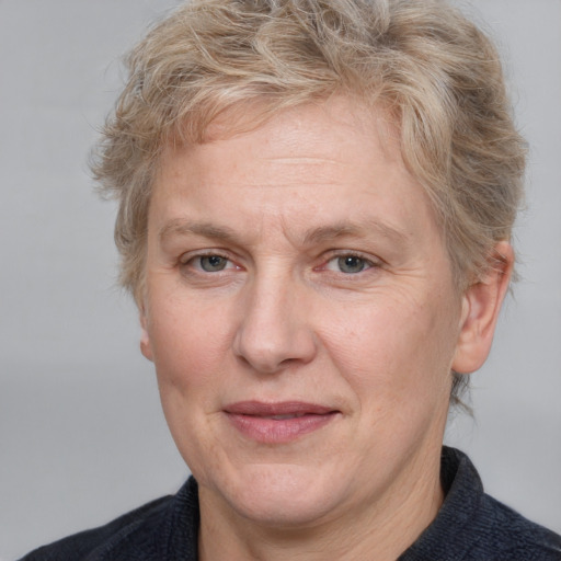 Joyful white middle-aged female with medium  brown hair and blue eyes