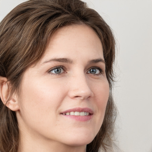 Joyful white young-adult female with long  brown hair and grey eyes