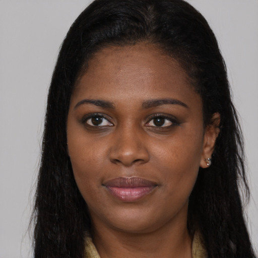 Joyful black young-adult female with long  brown hair and brown eyes