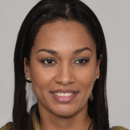 Joyful black young-adult female with long  brown hair and brown eyes