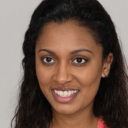 Joyful latino young-adult female with long  brown hair and brown eyes