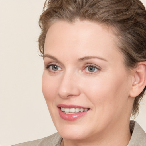 Joyful white young-adult female with medium  brown hair and blue eyes