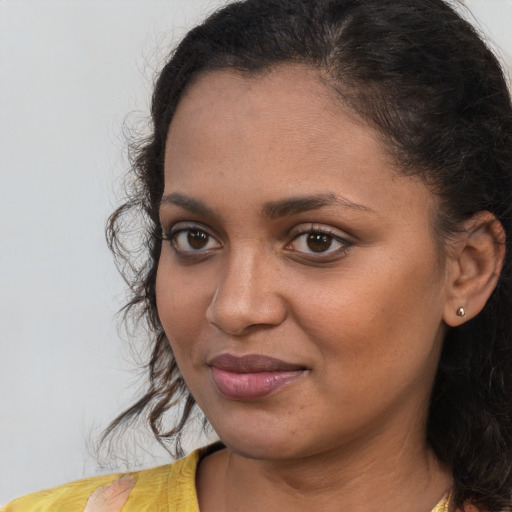 Joyful black young-adult female with long  brown hair and brown eyes