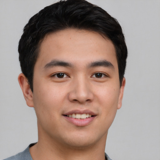 Joyful asian young-adult male with short  brown hair and brown eyes