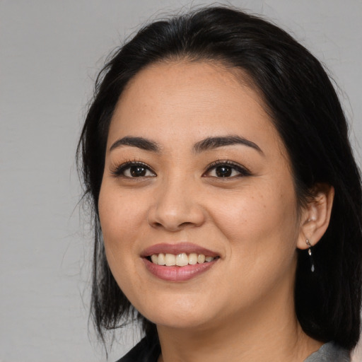 Joyful asian young-adult female with long  black hair and brown eyes