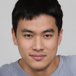 Joyful asian young-adult male with short  brown hair and brown eyes