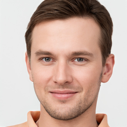 Joyful white young-adult male with short  brown hair and grey eyes