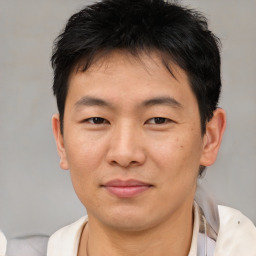 Joyful asian young-adult male with short  brown hair and brown eyes