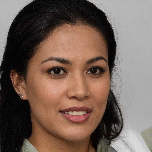 Joyful latino young-adult female with medium  brown hair and brown eyes