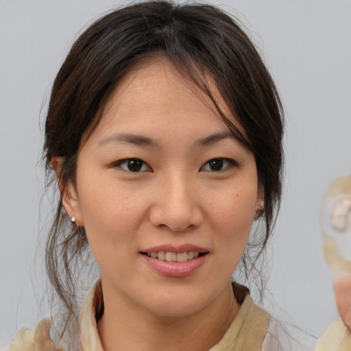 Joyful asian young-adult female with medium  brown hair and brown eyes