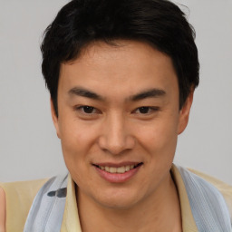 Joyful asian young-adult male with short  brown hair and brown eyes