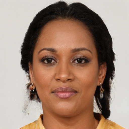 Joyful black adult female with medium  brown hair and brown eyes