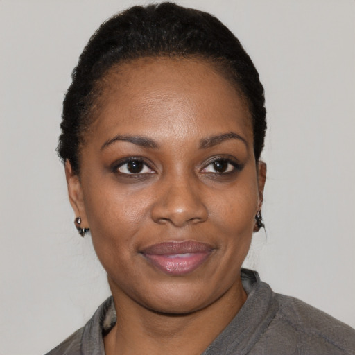 Joyful black young-adult female with short  black hair and brown eyes