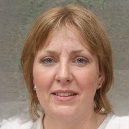 Joyful white adult female with medium  brown hair and blue eyes