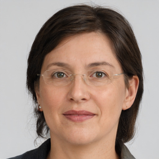 Joyful white adult female with medium  brown hair and grey eyes