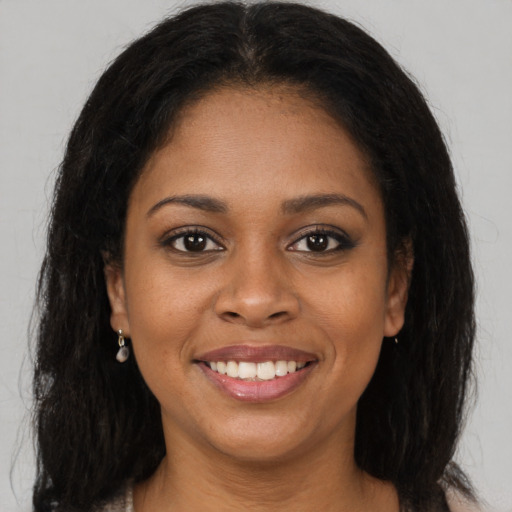 Joyful black young-adult female with medium  brown hair and brown eyes
