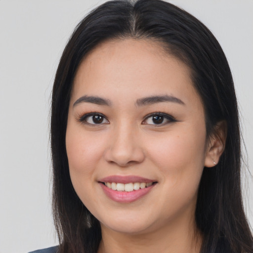 Joyful asian young-adult female with long  brown hair and brown eyes