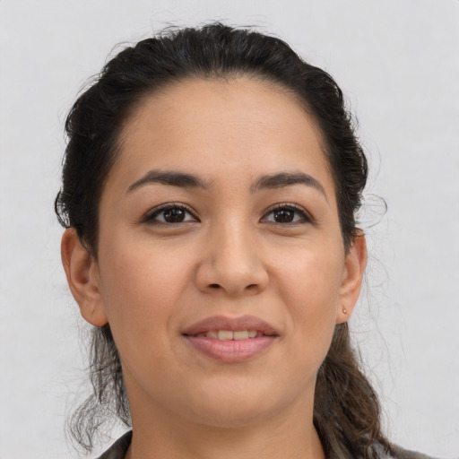 Joyful latino young-adult female with medium  brown hair and brown eyes