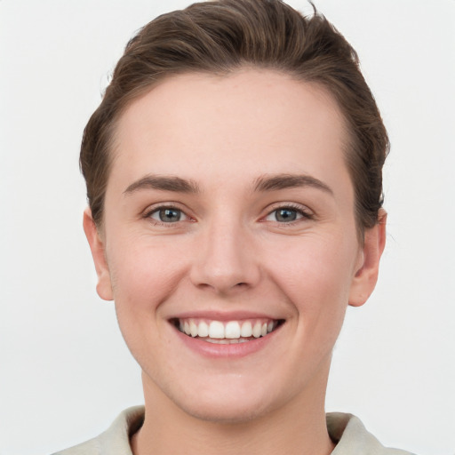 Joyful white young-adult female with short  brown hair and grey eyes