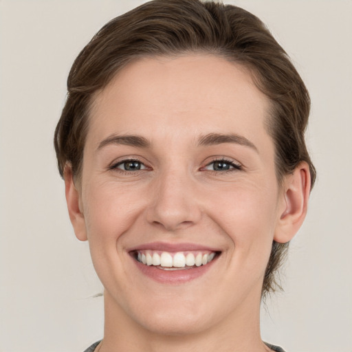 Joyful white young-adult female with short  brown hair and grey eyes