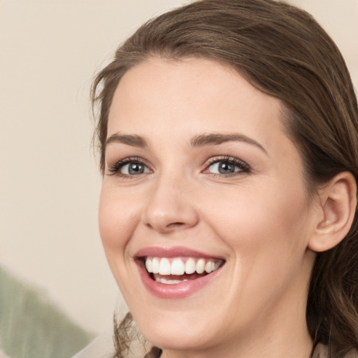 Joyful white young-adult female with medium  brown hair and green eyes