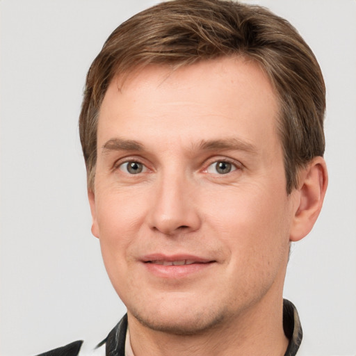 Joyful white young-adult male with short  brown hair and grey eyes