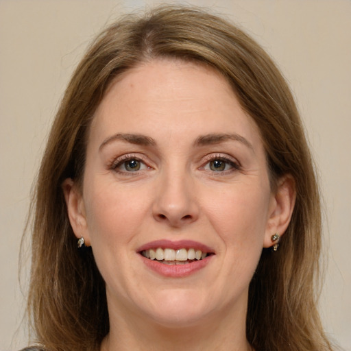 Joyful white adult female with long  brown hair and green eyes