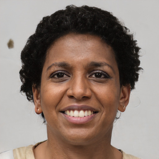 Joyful black young-adult female with short  brown hair and brown eyes