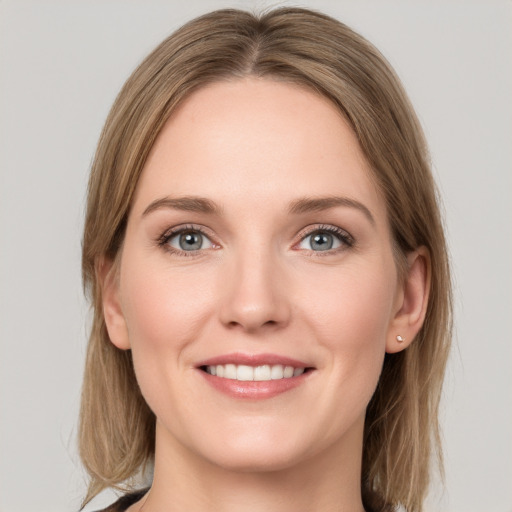 Joyful white young-adult female with medium  brown hair and grey eyes