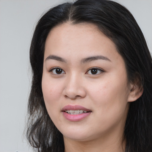 Joyful asian young-adult female with long  brown hair and brown eyes