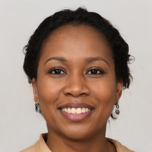 Joyful black young-adult female with short  brown hair and brown eyes