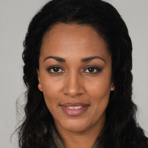 Joyful black young-adult female with long  black hair and brown eyes