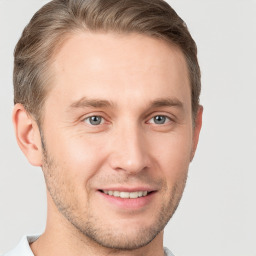 Joyful white young-adult male with short  brown hair and grey eyes