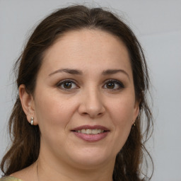 Joyful white adult female with medium  brown hair and brown eyes