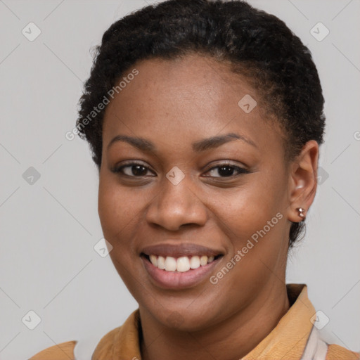 Joyful black young-adult female with short  brown hair and brown eyes