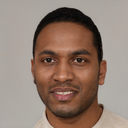 Joyful black young-adult male with short  black hair and brown eyes