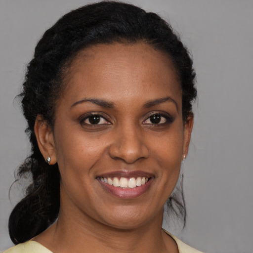 Joyful black young-adult female with medium  brown hair and brown eyes