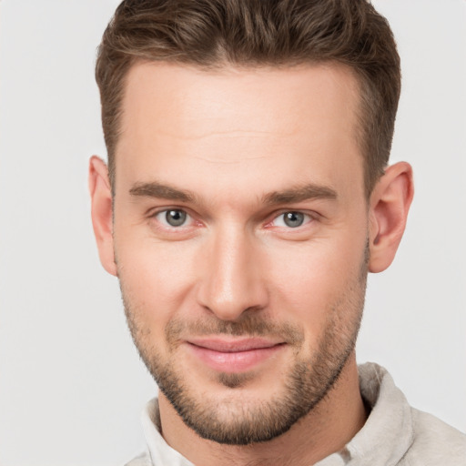 Joyful white young-adult male with short  brown hair and grey eyes