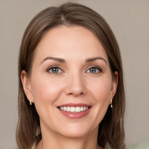 Joyful white young-adult female with medium  brown hair and grey eyes