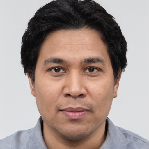 Joyful asian young-adult male with short  black hair and brown eyes