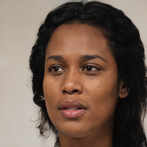 Joyful black young-adult female with long  black hair and brown eyes