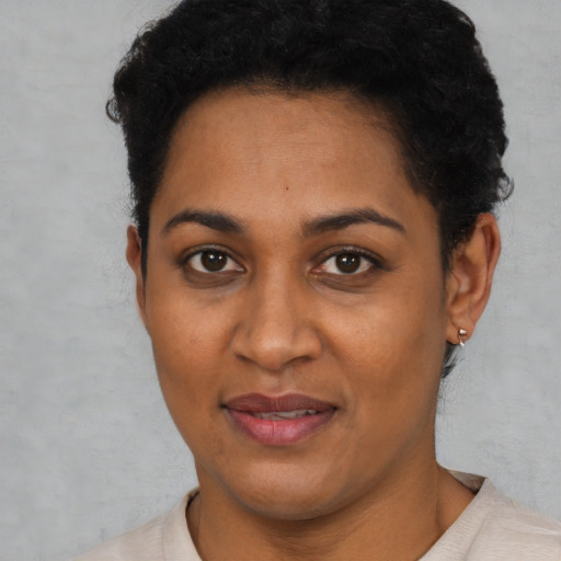 Joyful black young-adult female with short  black hair and brown eyes