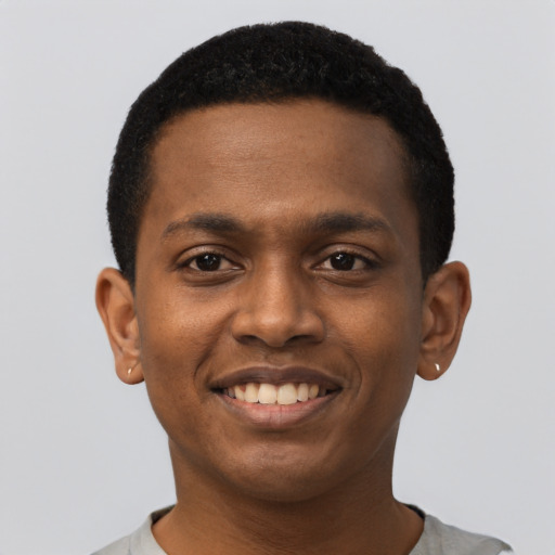 Joyful black young-adult male with short  black hair and brown eyes