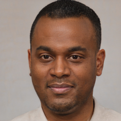 Joyful black young-adult male with short  black hair and brown eyes