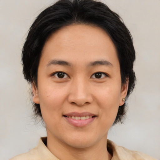 Joyful asian adult female with medium  brown hair and brown eyes