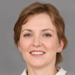 Joyful white young-adult female with medium  brown hair and grey eyes