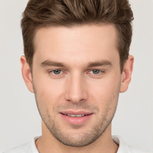 Joyful white young-adult male with short  brown hair and grey eyes